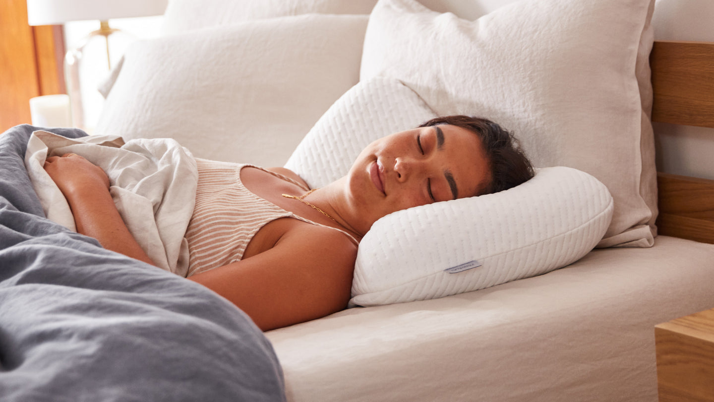 Woman laying on her back asleep on a Tuft 7 Needle foam pillow