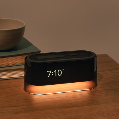 The  Tuft and Needle Loftie Smart Alarm Clock on a nightstand in a bedroom